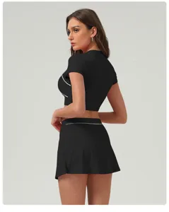 Vista dettagliata del set crop top sportivo nero e della gonna con profili bianchi.