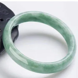 Elegant green jadeite bangle with natural floating colors, perfect for traditional and modern style.