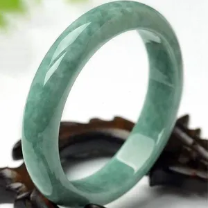 Green jadeite bangle detail shot, showcasing translucent green texture and elegant style.