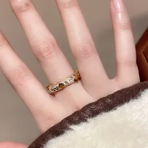 Nahaufnahme eines unregelmäßigen offenen Rings mit Zirkon- und Tigeraugensteinen.