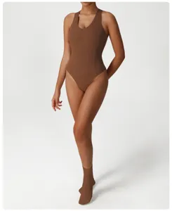 Body da yoga intero a costine marrone, abbigliamento fitness aderente dettaglio tessuto.