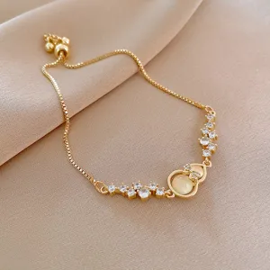 Elegant gold-plated adjustable bracelet with sparkling cubic zirconia and bow charm for daily wear.