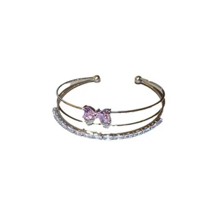 Elegant double-layer open bangle featuring a sparkling pink crystal bow and sparkling zirconia.
