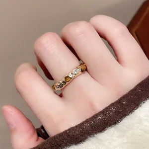 Nahaufnahme Detail des unregelmässigen Vintage Goldrings mit Tigerauge und funkelndem Zirkon.