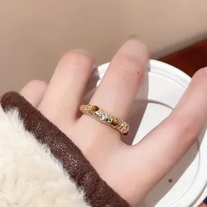 Nahaufnahme eines vintage unregelmässigen Metallrings mit Tigerauge und Zirkoniasteinen.
