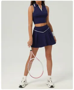 Detail view of the navy blue athletic crop top and pleated tennis skirt set with white trim.