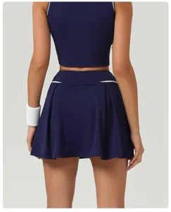 Back view detail of women's navy blue athletic crop top and pleated sports skirt outfit.