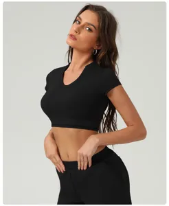 Gros plan détaillé du crop top court noir à manches courtes pour le fitness et l'entraînement de yoga.