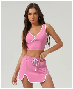 Close-up detail of the pink athletic crop top and matching skirt, featuring crisp white trim.