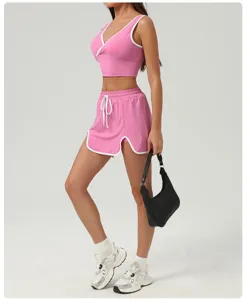 Ensemble de sport rose avec bordures blanches contrastées, soutiens-gorge et short de course.