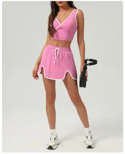 Detailed view of women pink activewear set, sleeveless v-neck top and skirt with white trim.