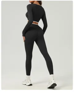 Detailed view of black long sleeve crop top and high waist yoga pants athletic fitness set.