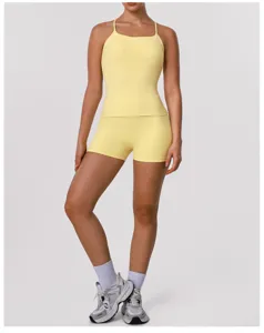 Gedetailleerd overzicht van een gele sport crop top en yoga shorts set met gekruiste bandjes.