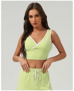 Vue détaillée du crop top de sport vert clair avec col V croisé et bordure blanche contrastante.