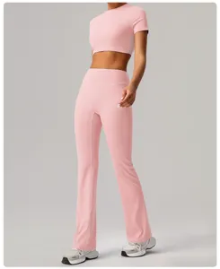 Close-up detail of the pink crop top and high-waisted flared yoga pants set, elastic fit.