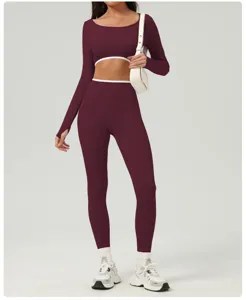Close-up detail of the maroon long-sleeve crop top and high-waist yoga leggings with white trim.