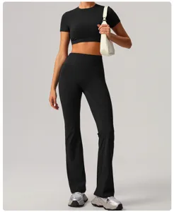 Detailed view of black athletic crop top and high waist flared yoga trousers outfit.