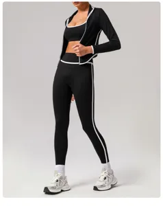 Detailed view of the women's black athletic zip-up jacket and yoga leggings set with contrast piping.