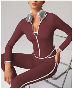 Women's slim fit athletic yoga jacket and leggings set in dark red with white contrast trim.