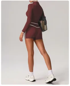 Women athletic fitness set high waist yoga shorts and long sleeve top with contrast trim.