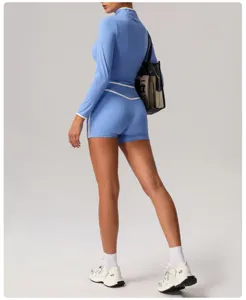 Blue long sleeve athletic crop top and high waist yoga shorts set with white trim details.