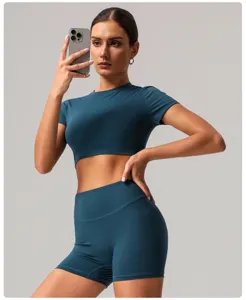 Detail view of women quick drying short sleeve athletic crop top and high waist yoga shorts set.