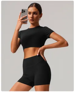Detail view of black athletic crop top and high waist shorts, quick drying nude feel fabric.