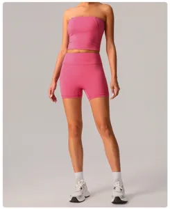 Dettaglio top yoga rosa senza spalline e pantaloncini a vita alta in tessuto elastico traspirante.