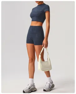Detailed view of dark blue short sleeve crop top and shorts fitness set with silver print.