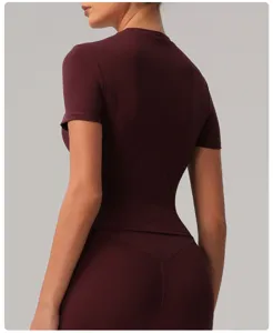 Back view detail of women's burgundy short sleeve athletic yoga top, slim fit workout shirt.