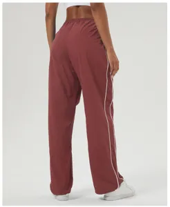 Detail view of casual loose straight track pants with contrast side stripes, back view.
