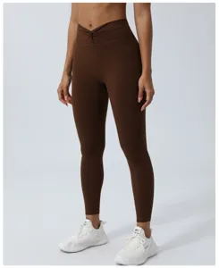 Vista dettagliata dei pantaloni yoga marroni con vita incrociata, controllo pancia e push-up.