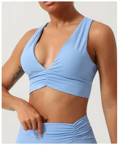 Gros plan sur le soutien-gorge de yoga bleu clair en V avec fronces et maintien sport.