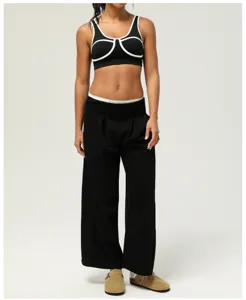 Vue détaillée du soutien-gorge de sport contrasté pour femmes et du pantalon large noir.