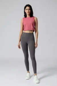 Dames roze korte sporttanktop en grijze hoge taille yoga leggings sportkleding detail.