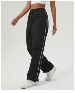Detail view of black casual athletic trousers featuring contrast white side stripes and drawstring.