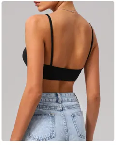 Reggiseno sportivo nero aperto dietro da donna, top fitness elegante e jeans casual.