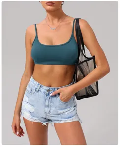 Set reggiseno sportivo verde da donna e pantaloncini in denim azzurro, abbigliamento fitness.