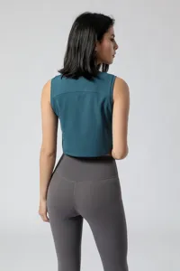 Achterkant van een turquoise mouwloze yogatop met passende grijze fitnesslegging.