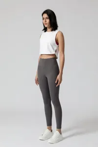 Close-up detail van een witte korte sporttanktop voor dames met grijze leggings.