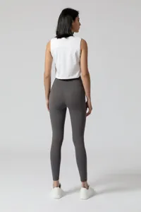 Dames sport yoga set met een witte mouwloze crop top en donkergrijze actieve leggings.