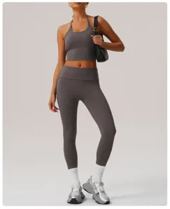 Conjunto deportivo gris con top corto halter y pantalones de cintura alta para fitness.