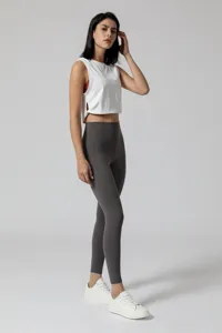 Gedetailleerd aanzicht van de witte sport crop top en donkergrijze hoge yoga leggings.