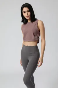 Gedetailleerd overzicht van de mouwloze korte yoga-top en grijze fitnesslegging.
