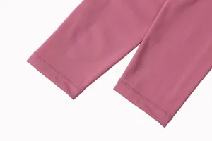 Gros plan sur le revers du pantalon de yoga rose avec tissu brossé lisse et double surpiqûre.