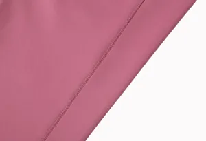 Gros plan détaillé sur le tissu de pantalon de yoga brossé et les coutures soignées.
