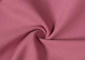 Gros plan sur le tissu de pantalon de yoga brosse doux en rose, montrant une texture extensible.