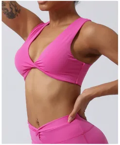 Détail de soutien-gorge de sport rose torsadé sur le devant, design froncé et couleur vive.