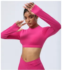 Rosa langarm bauchfreies Yoga-Oberteil und Leggings Detailansicht, elastische Sportbekleidung.