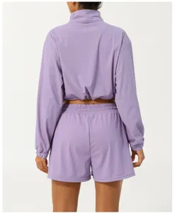 Ensemble de sport violet pour femme avec haut demi-zip et short anti-UV d'extérieur.